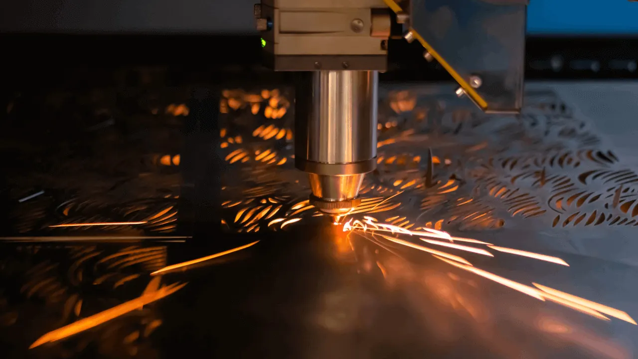 Fiber laser cutting head cutting a steel sheet at Ferum Engineering